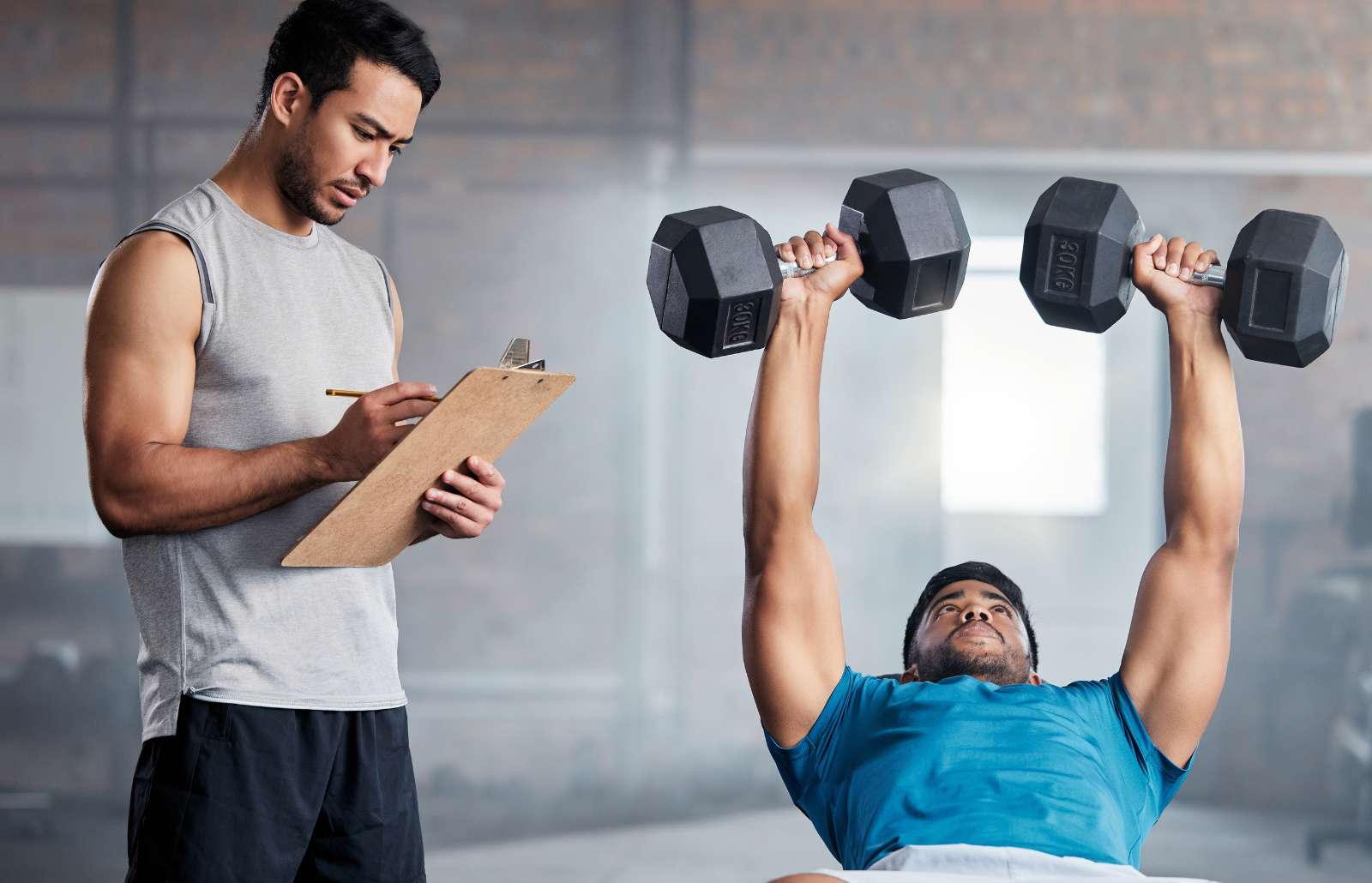 Fitness, body builder and weight, coach or personal trainer with checklist, exercise or training in gym with motivation. Man coaching, workout or bodybuilder with muscle, strong or athlete commitment