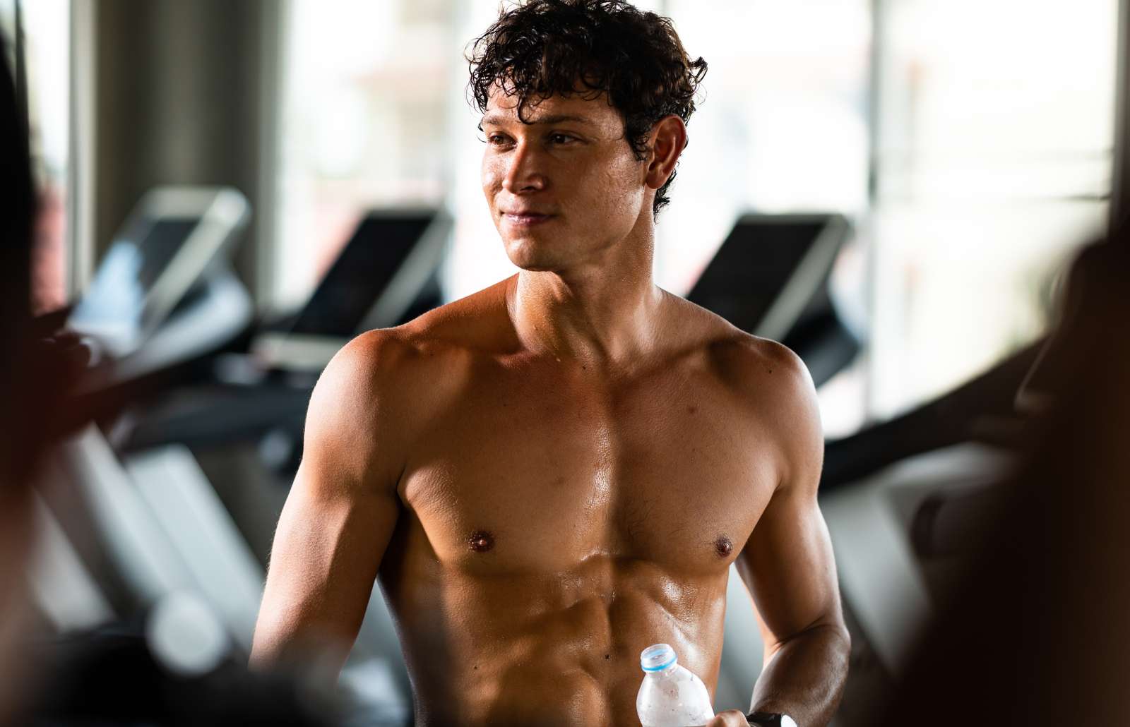 caucasian athlete man person drink a bottle of fresh water after workout in sport gym, adult male exercise in fitness for building strong body, take a break of muscular healthy training lifestyle