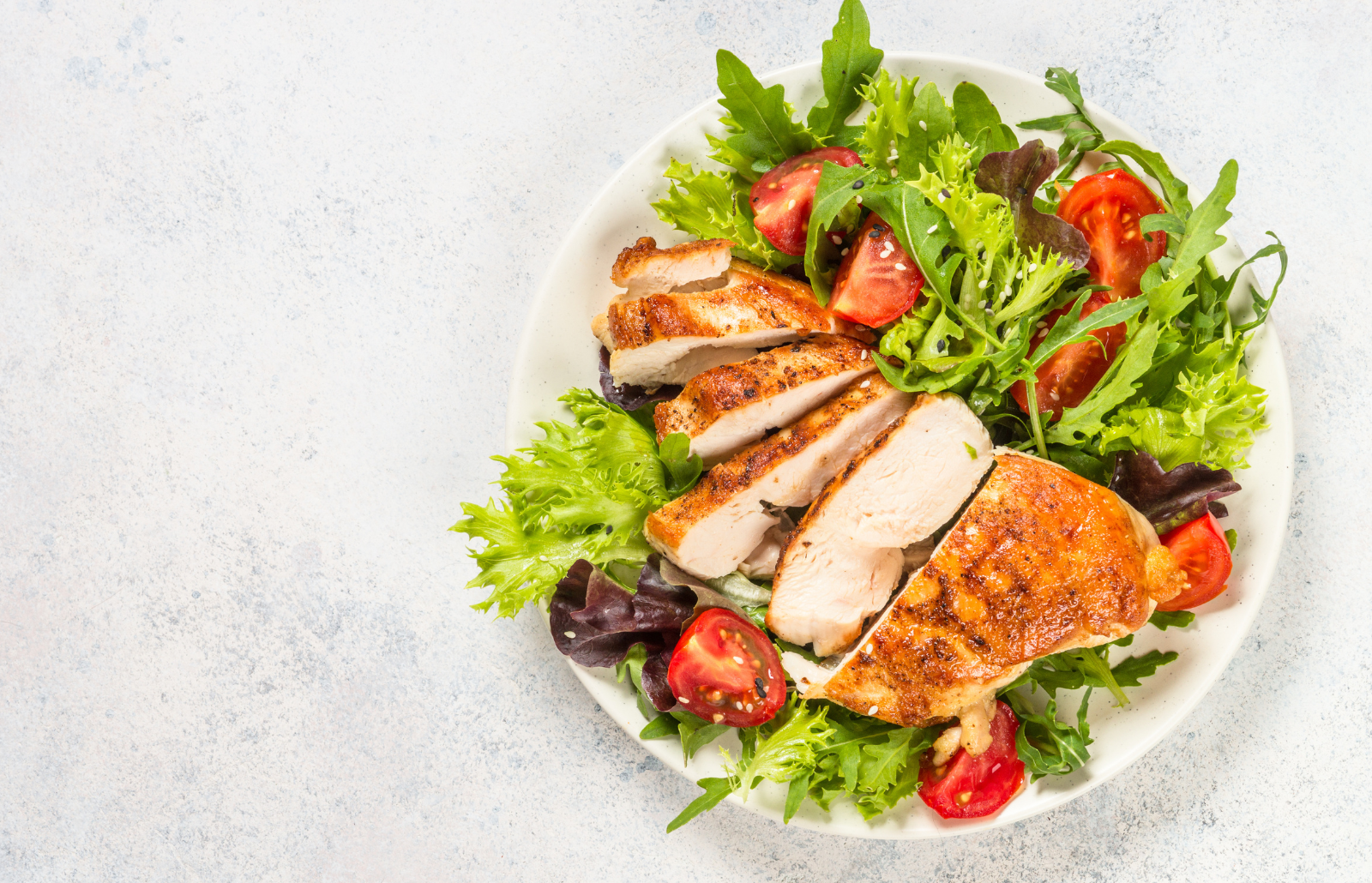 Grilled chicken with fresh salad. Keto diet, healthy eating. Top view on white table with space for text.