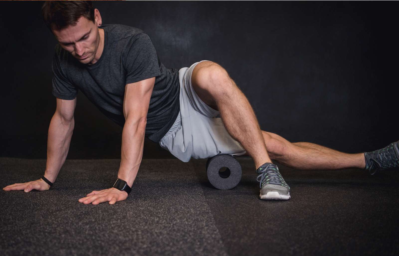 Athletic man using a foam roller to relieve sore muscles after a workout.