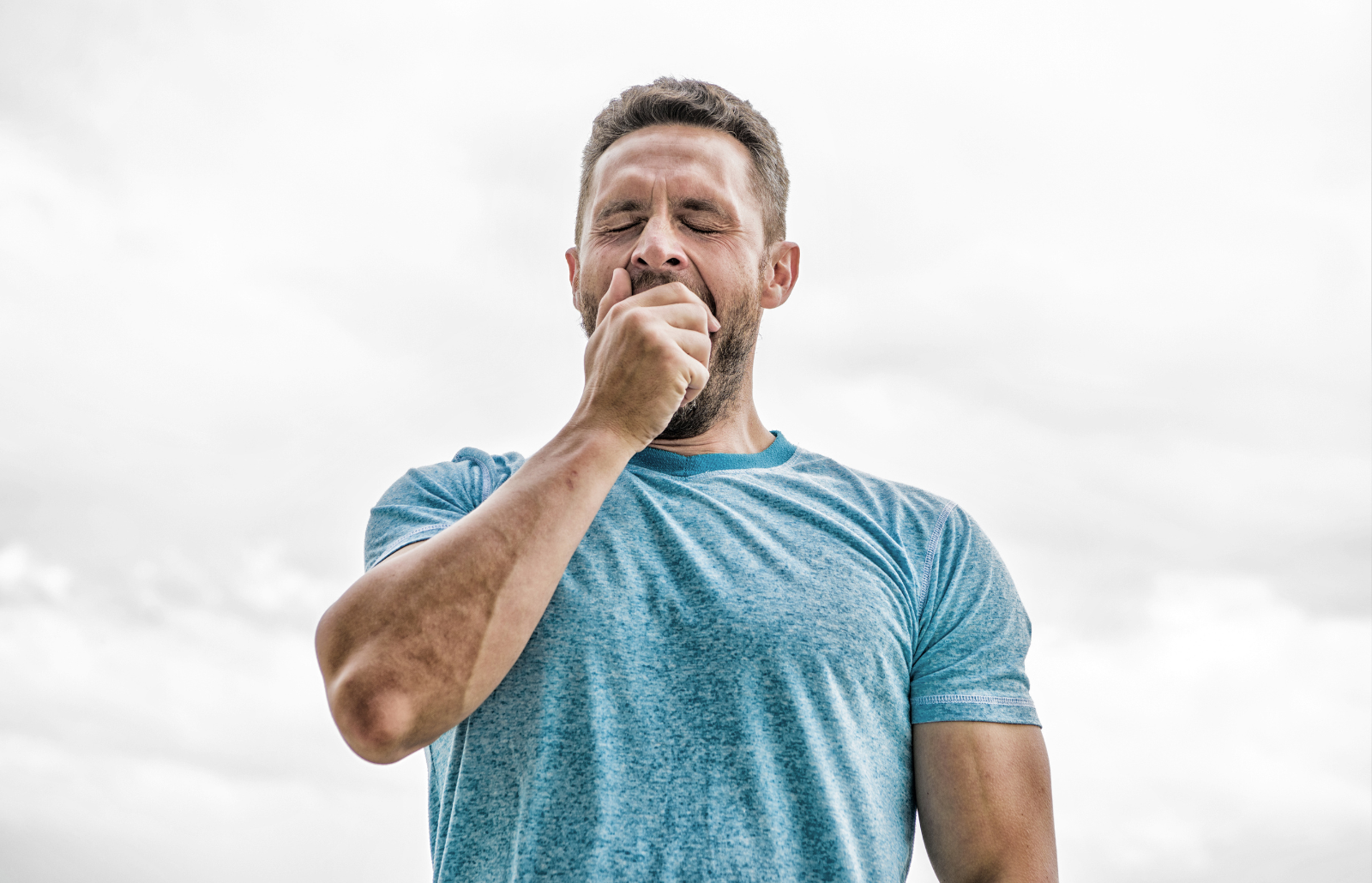 after workout. man athlete in blue sport tshirt. sportswear fashion. yawning muscular male with beard. sleepy man isolated on white. sportsman with athletic body. coach in fitness gym. wakeup morning.
