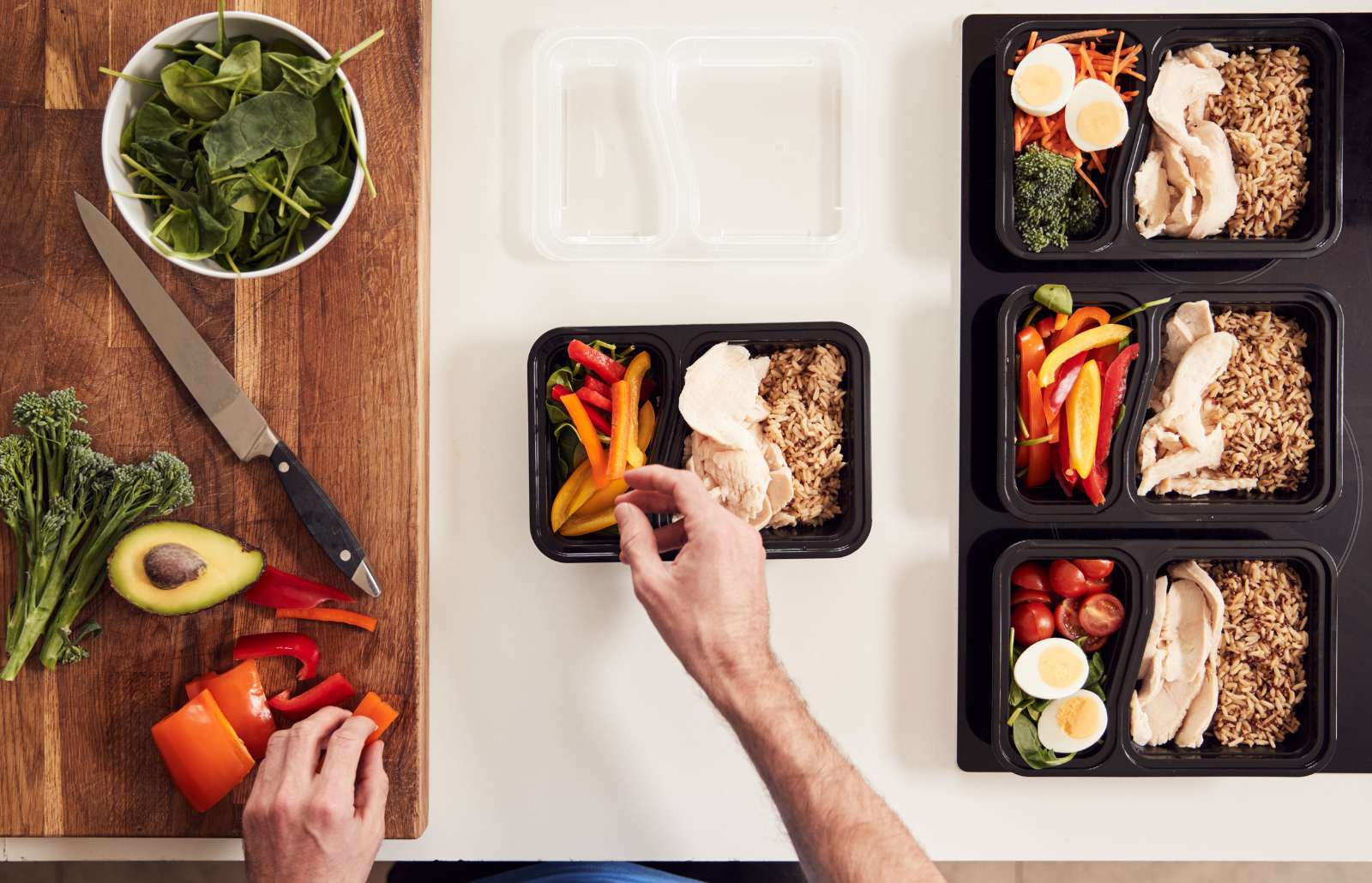Overhead Shot Of Man Preparing Batch Of Healthy Meals At Home In Kitchen