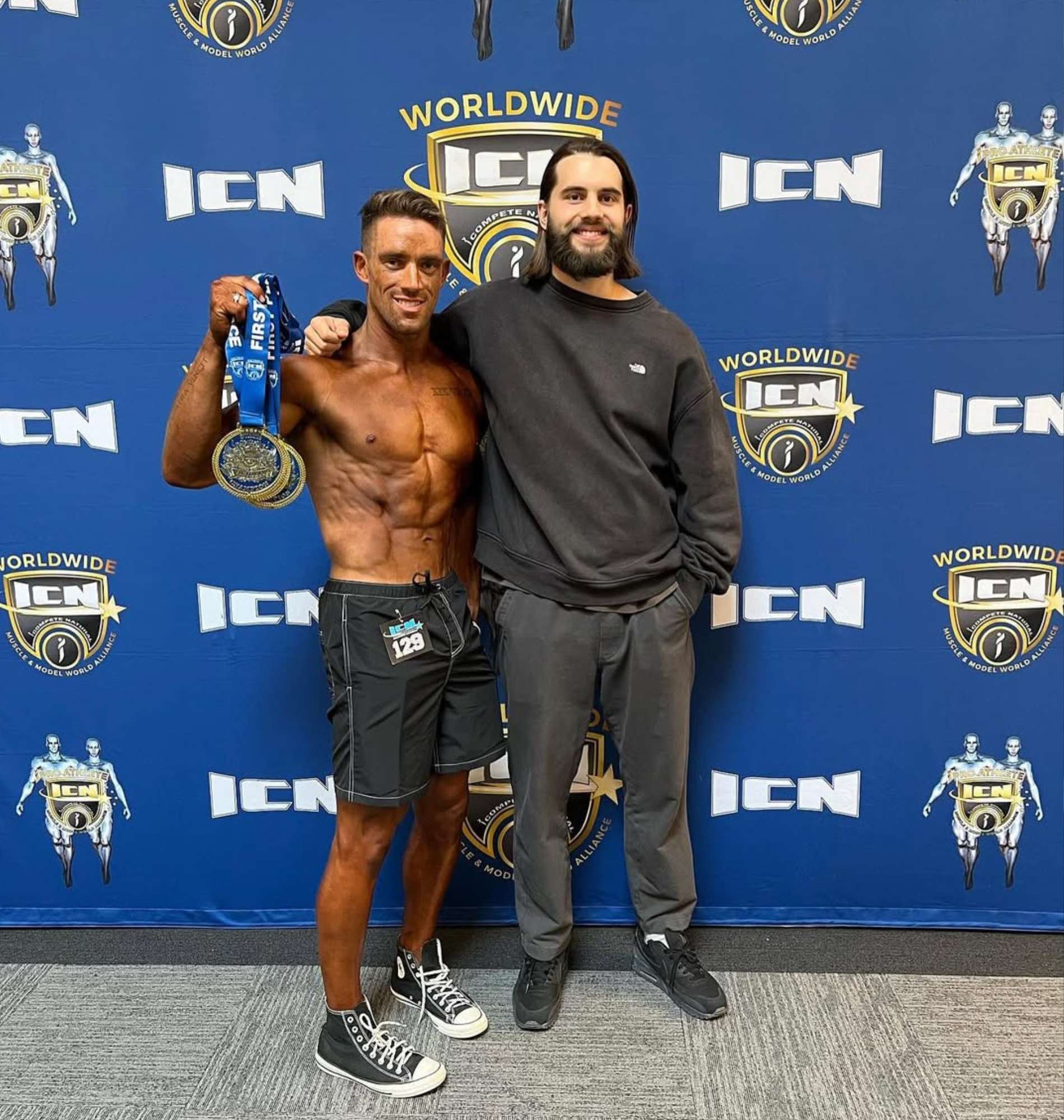 Strength Lab client holding medals after physique competition prep in Melbourne with coach Jack Vance