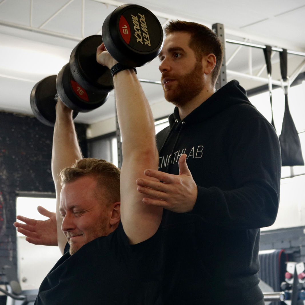 Client lifting weights with coach guidance during personal training in Melbourne at Strength Lab
