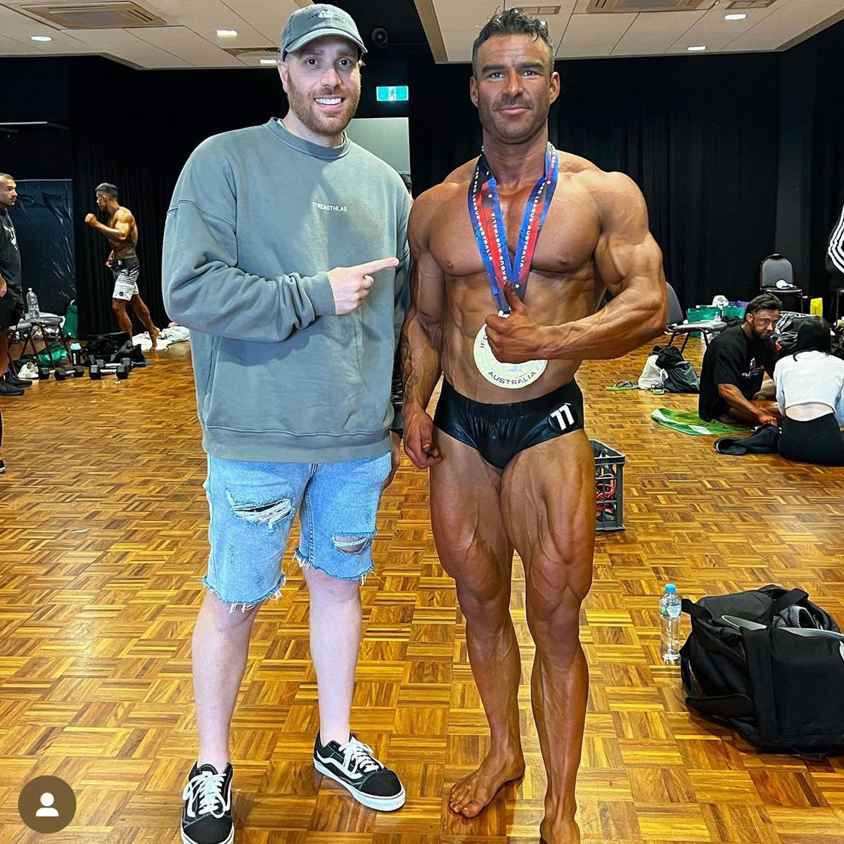 Strength Lab coach celebrating with client after winning competition medals