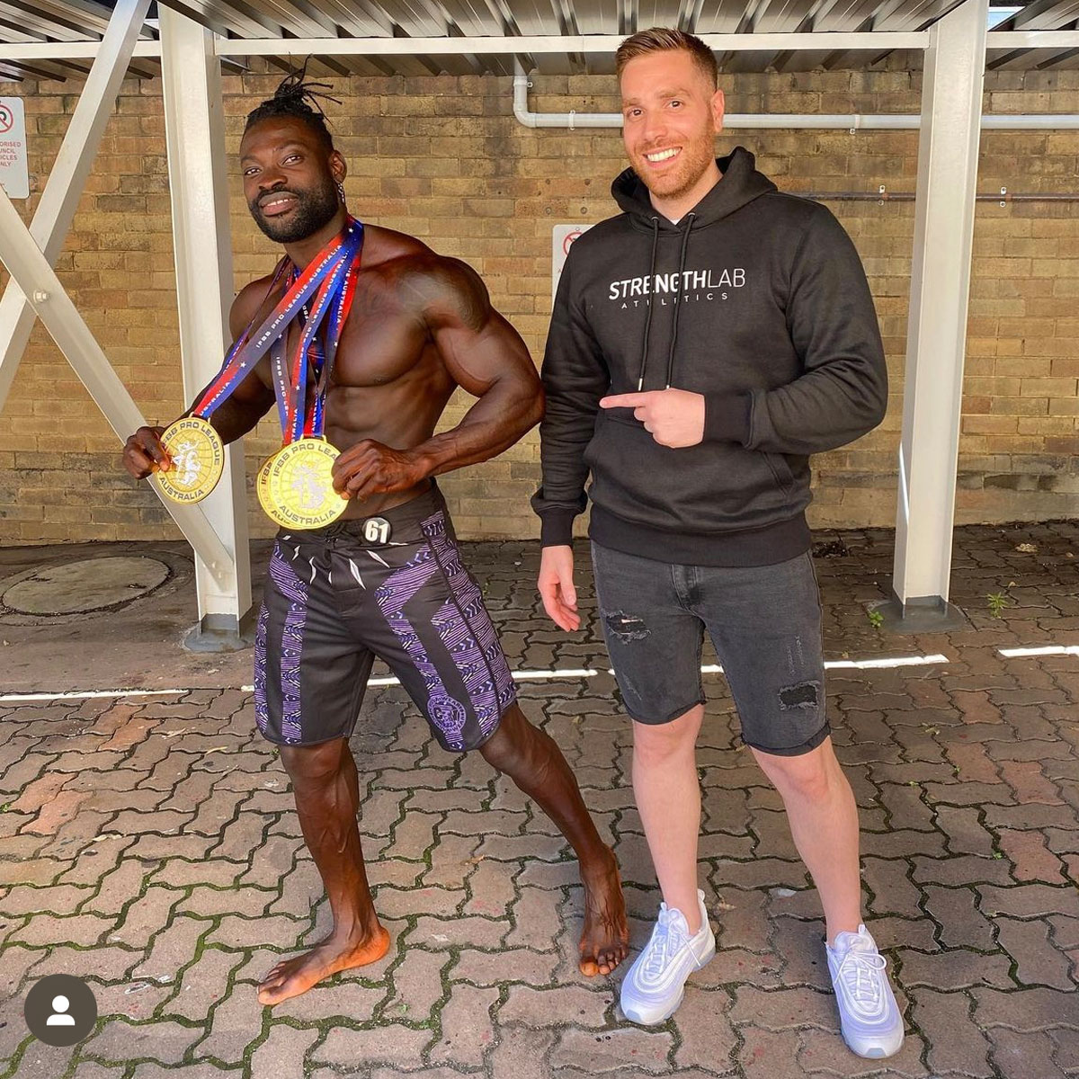 Strength Lab coach celebrating with client after winning competition medals