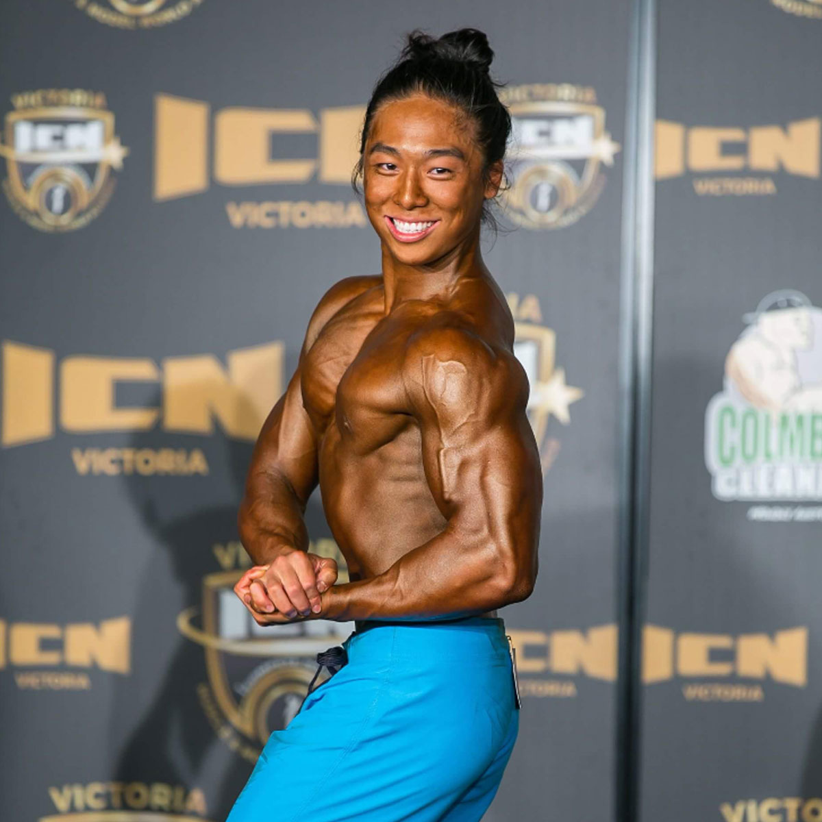 Male physique competitor flexing during contest after Strength Lab prep
