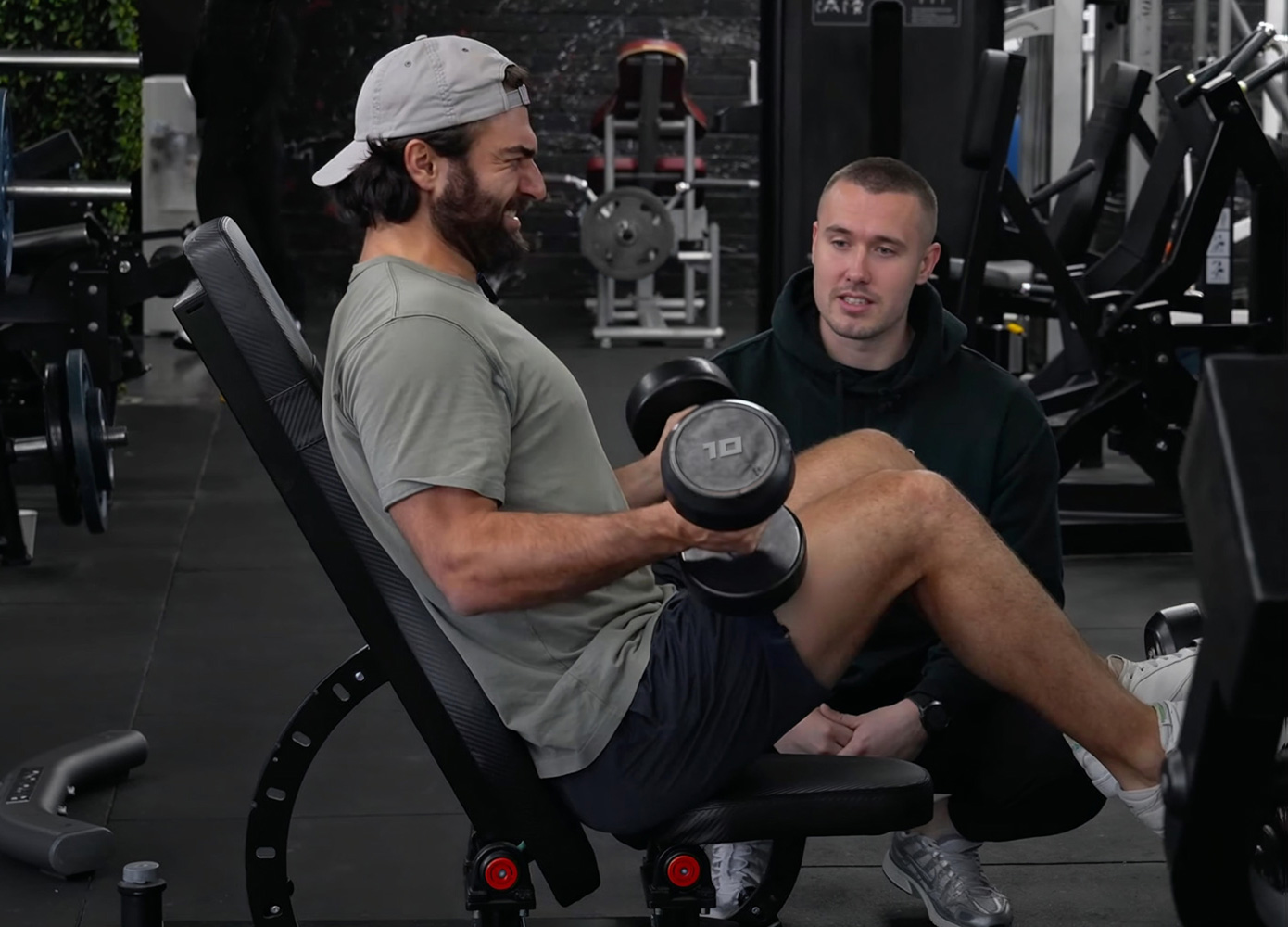 Client lifting weights under the guidance of a Strength Lab personal trainer during a coaching session