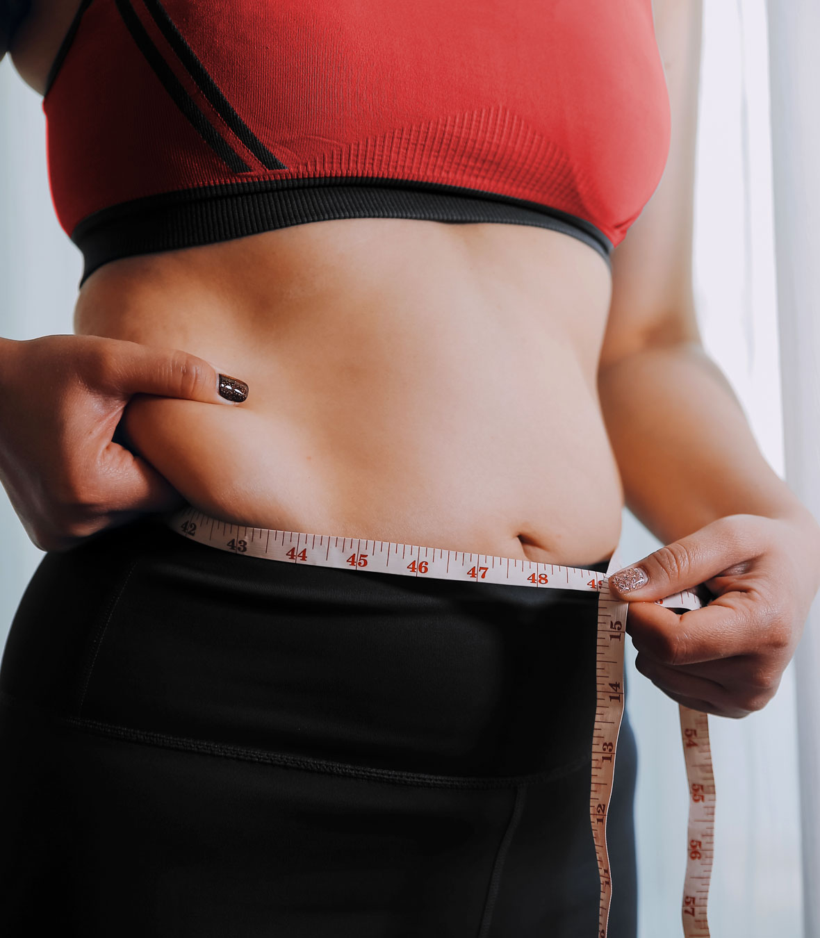 Female client measuring her own waist during fat loss training at Strength Lab Melbourne